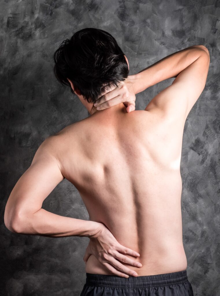 a man with back pain on grey background